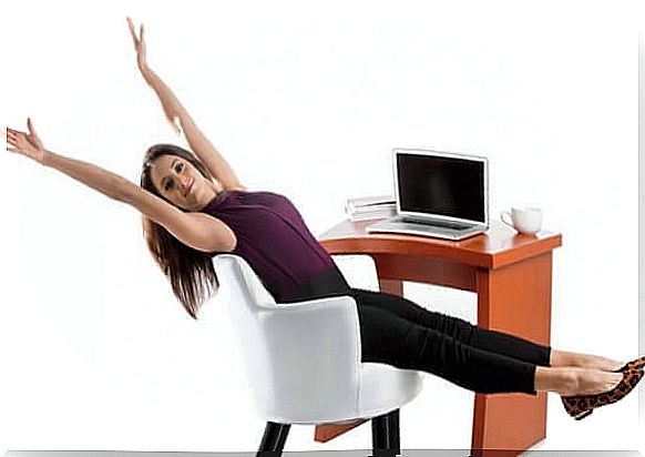 The woman is exercising at the desk