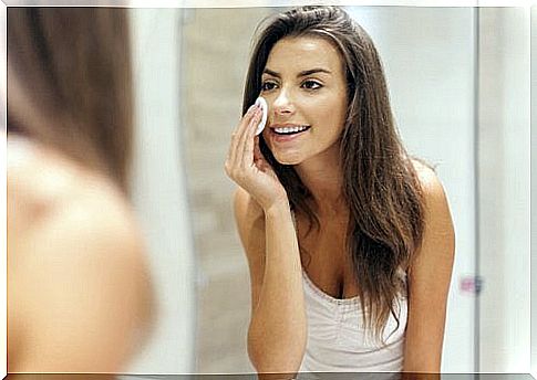 The woman cleans the skin of her face to apply an astringent cream