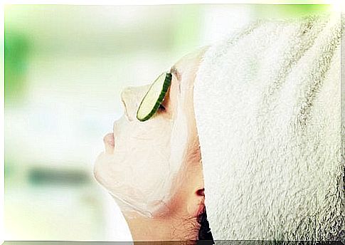 A woman with a mask and cucumbers removes dark spots on her face